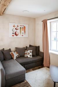 een woonkamer met een bank en een raam bij Gîte de la maraîchère in Ittre +13 foto's