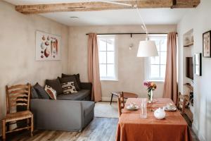 a living room with a table and a couch at Gîte de la maraîchère in Ittre