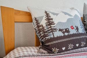 SchwändiにあるLodge of Sardonaのベッドの上に木の絵が描かれた枕