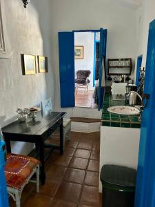 een keuken met een tafel en een blauwe deur bij Guesthouse La Tienda Cómpeta 21b in Cómpeta