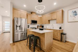 a kitchen with wooden cabinets and a stainless steel refrigerator at Bright & Cozy 4BR Retreat Near Downtown Gresham in Gresham