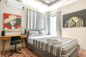 - une chambre avec un lit, un bureau et un tableau dans l'établissement Puerto Rico vacation dream house, à San Juan 65 autres photos
