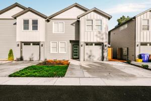 a large white house with a garage at Bright & Cozy 4BR Retreat Near Downtown Gresham in Gresham