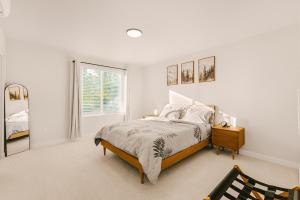 a white bedroom with a bed and a window at Bright & Cozy 4BR Retreat Near Downtown Gresham in Gresham