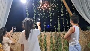 a group of people standing in front of a wall with fireworks at Hotel Naqsh-band Terrace in Bukhara