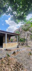 a small house with a mountain in the background at Abrigo Quixadá in Quixadá