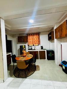 a kitchen with a table and chairs in a room at Modern 2-Bedroom Apt with African Vibe- Cape Coast in Cape Coast