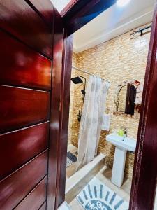 a bathroom with a shower and a sink at Modern 2-Bedroom Apt with African Vibe- Cape Coast in Cape Coast