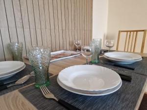 a table with plates and wine glasses on it at Casa Cristina in Pécs