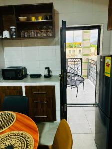 a kitchen with a door open to a balcony at Modern 2-Bedroom Apt with African Vibe- Cape Coast in Cape Coast +4 photos