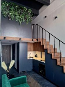 un salon avec un escalier et un canapé vert dans l'établissement Stylish loft, à Vilnius