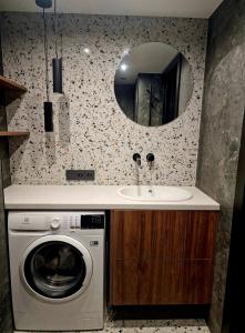 une salle de bains avec lave-linge et lavabo dans l'établissement Stylish loft, à Vilnius