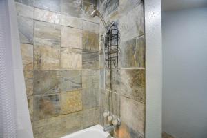 a shower in a bathroom with a stone wall at 6 Mi to Laughlin AFB Cozy Studio with Private Yard in Del Rio +17 photos