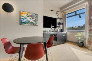 a living room with a table and chairs and a tv at Arctic Comfort Hotel in Reykjavík