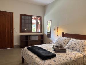 een slaapkamer met een bed met een zwart kussen erop bij Itamambuca Suites in Ubatuba +48 foto's