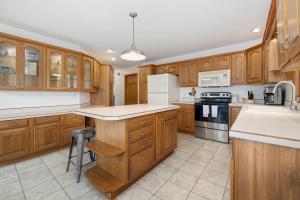 a kitchen with wooden cabinets and white appliances at Beavershore-Direct Access to Beaver Lake-Sleeps 12 in Pine Top +27 photos