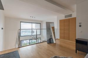 an empty living room with a staircase and a large window at Loft moderno con terraza y piscina en Valencia in Burjasot