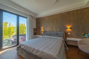 a bedroom with a bed and a large window at Dream house in Olbia
