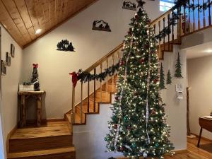 a christmas tree in a room with a staircase at Smoky Mountain Getaway cabin in Cosby