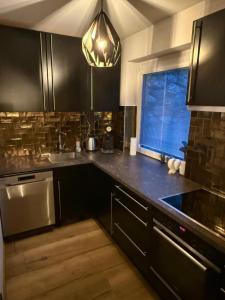 a kitchen with black cabinets and a sink and a window at Chalet Pallegg in Hinterthal