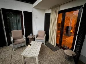 a porch with two chairs and a table and a bench at Chalet Pallegg in Hinterthal