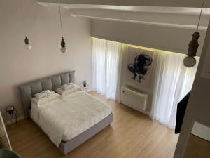 Un dormitorio con una cama con sábanas blancas y cortinas blancas. en Off House Borgo Suite, Nettuno, en Nettuno