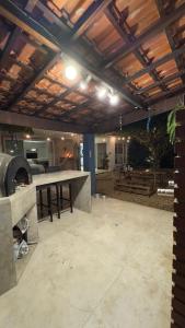 a large outdoor kitchen with a grill and a table at Charmosa hospedagem no Jardim Secreto SP in Sao Paulo