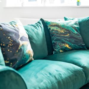 un canapé vert avec deux oreillers dessus dans l'établissement Modern 2Bed Apartment - Netflix - Parking 55C, à Sleightholme 29 autres photos