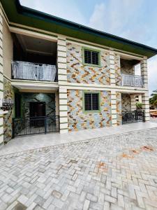 a house with a stone wall and a patio at Modern 2-Bedroom Apt with African Vibe- Cape Coast in Cape Coast