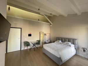 Un dormitorio con una cama grande y una mesa. en Off House Borgo Suite, Nettuno, en Nettuno