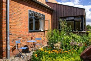 a brick building with a table and chairs in a garden at Idyllic Country House Between Hamburg And Berlin in Langen Jarchow