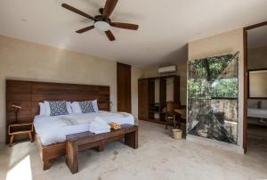 a bedroom with a bed and a ceiling fan at Casa Kookay, 6BR Luxury Villa 3 Pools, Aldea Zama in Tulum
