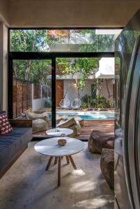 sala de estar con mesa y piscina en Casa Kookay Luxury Villa in Tulum, en Tulum