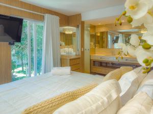 een grote slaapkamer met een groot bed en een televisie bij Mont Ararat Alto da Pitinga - Rede Tonziro in Porto Seguro +118 foto's