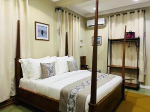 a bedroom with a canopy bed with white pillows at The Dawn cottage in Moshi