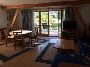 un soggiorno con TV, tavolo e sedie di Haus Astrid a Keutschach am See