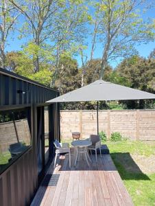 a patio with a table and an umbrella at Container Stay - Taupo in Taupo