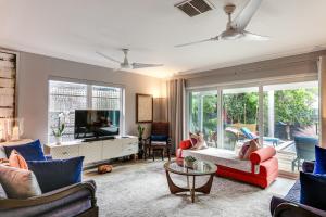 a living room with two couches and a tv at 1 Mi to Lake Worth Beach Park Poolside Paradise! in Lake Worth