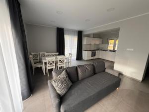 a living room with a couch and a dining room at Domy całoroczne Cieszyno in Cieszyno +5 photos