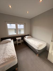 a bedroom with two beds and a table in it at Domy całoroczne Cieszyno in Cieszyno