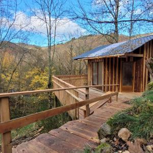 uma passagem de madeira que leva a uma cabana na floresta em Cabane octogone sauvage - Octogonia, Ardèche em La Rochette