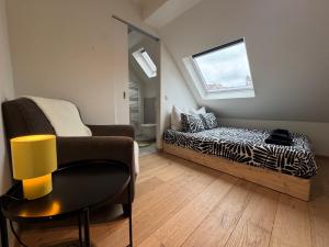 a living room with a bed and a chair at Spacious and Design Loft in Brussels