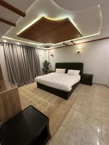 ein Schlafzimmer mit einem Bett und einer Kassettendecke in der Unterkunft Hotel SecondHome in Murree