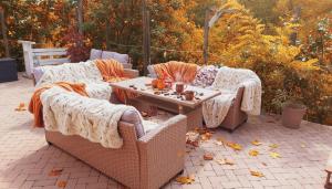 zwei Korbsofas und ein Couchtisch auf einer Terrasse in der Unterkunft Chillinn Bikavér Cottage Eger in Eger