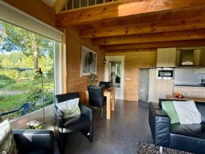 a living room with a table and chairs and a kitchen at De Boase in Voorthuizen