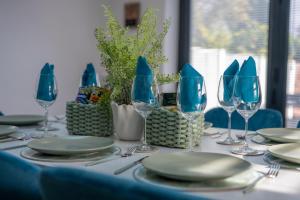 a table with plates and wine glasses on it at Cosy Clay Home, Near Airport, NEC, City Centre in Birmingham