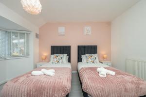 een slaapkamer met twee bedden met handdoeken erop bij Cosy Clay Home in Birmingham