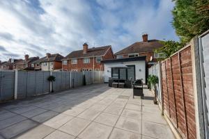 een patio met een hek en een gebouw bij Cosy Clay Home in Birmingham