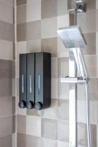 een badkamer met een zwarte zeepdispenser aan de muur bij Cosy Clay Home in Birmingham +55 foto's