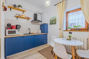 una cucina con mobili blu e tavolo di Arctic Apartment a Braşov